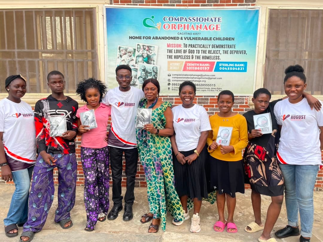 Team members and children smiling together with books after an outreach visit